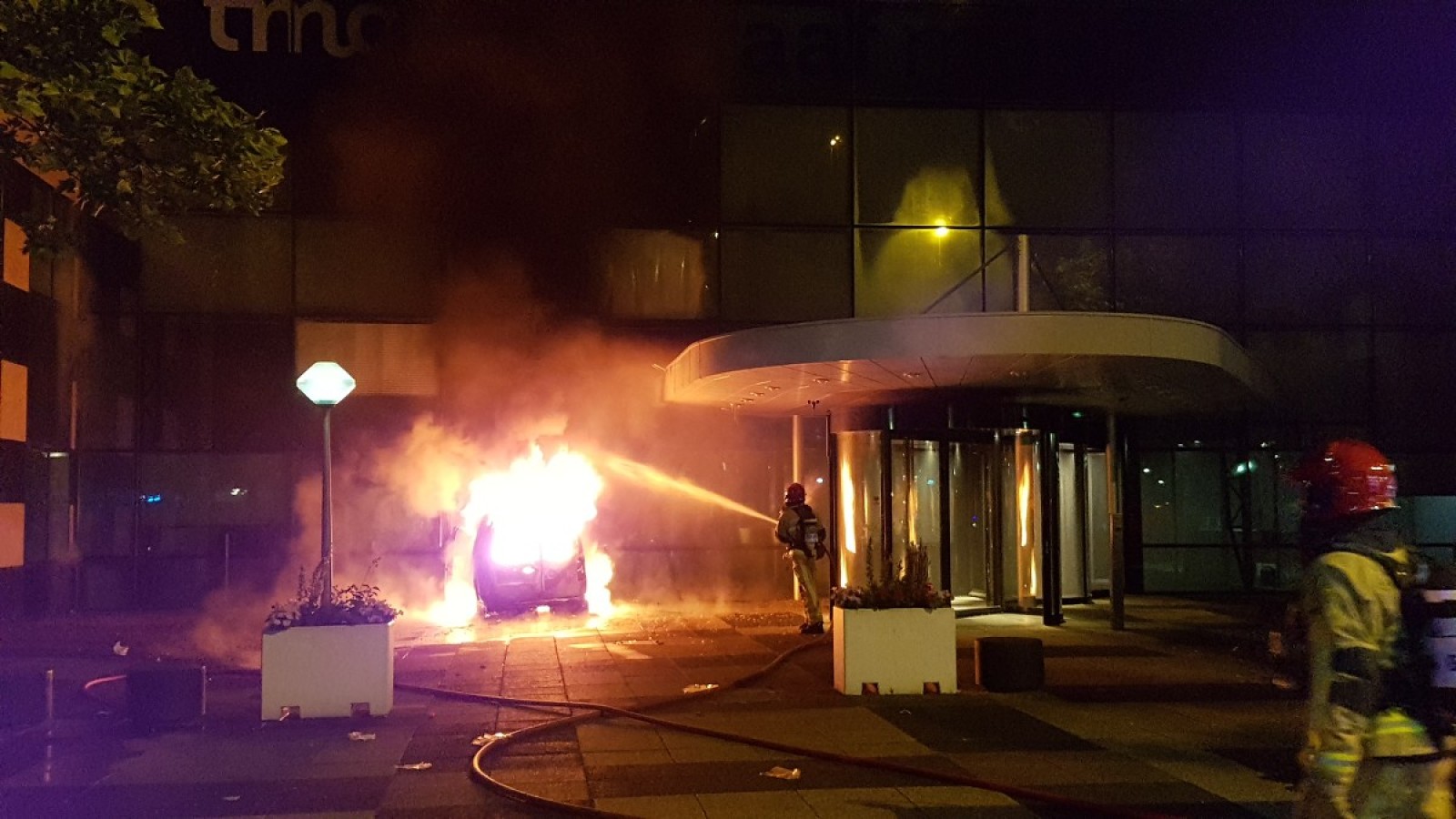 Busje rijdt kantoorpand De Telegraaf binnen en vliegt in brand
