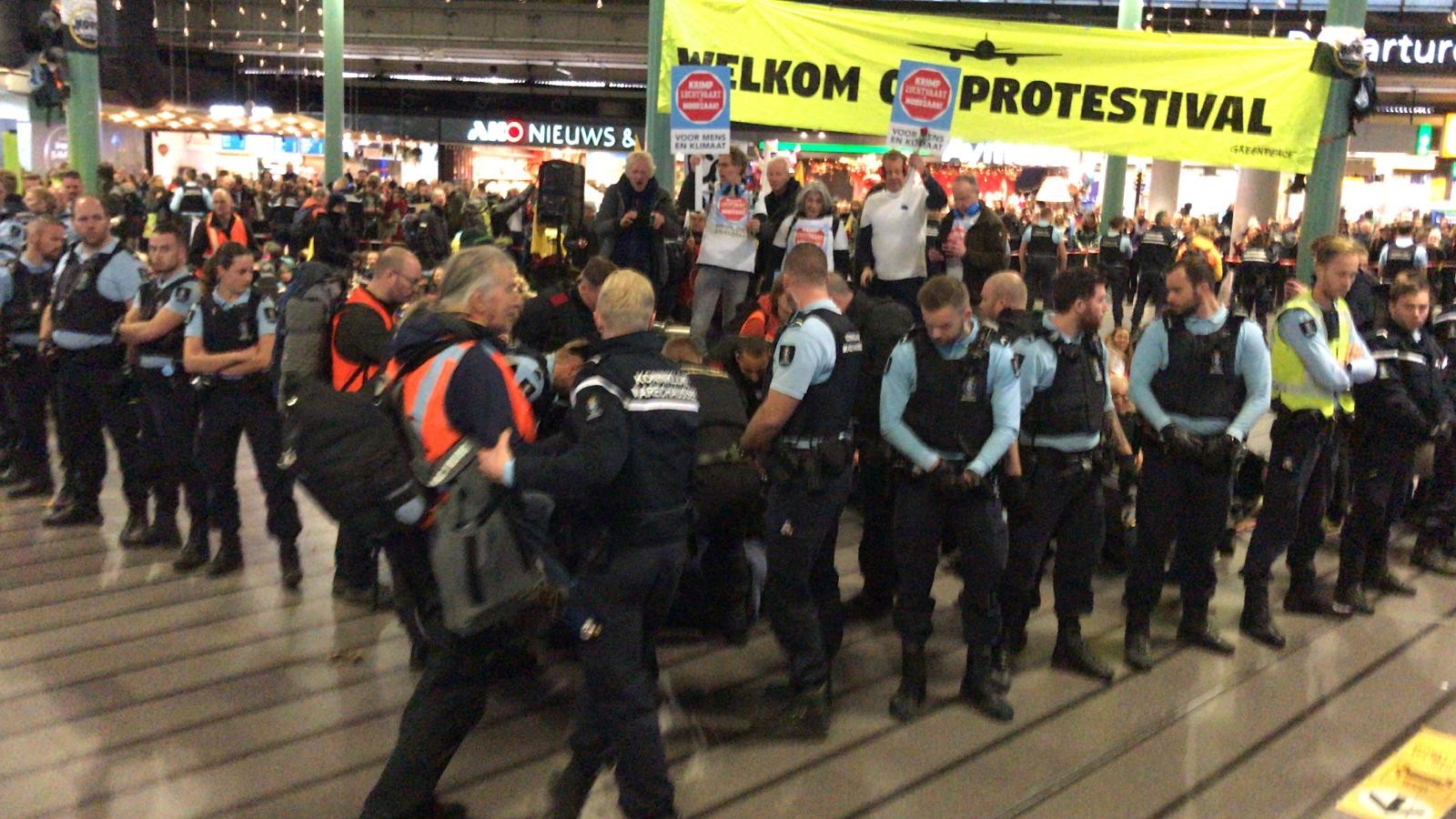 Activisten Schiphol Plaza weigeren te vertrekken, Marechaussee schaalt op