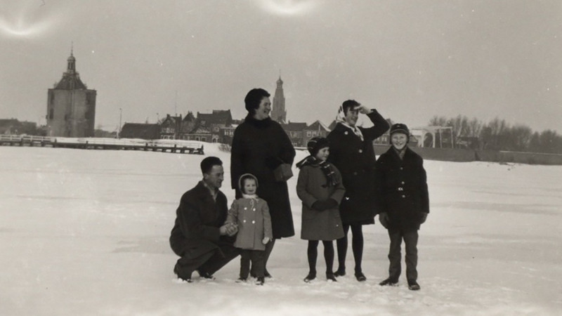 Familie Appel op het ijs (IJsselmeer) met in de achtergrond Enkhuizen