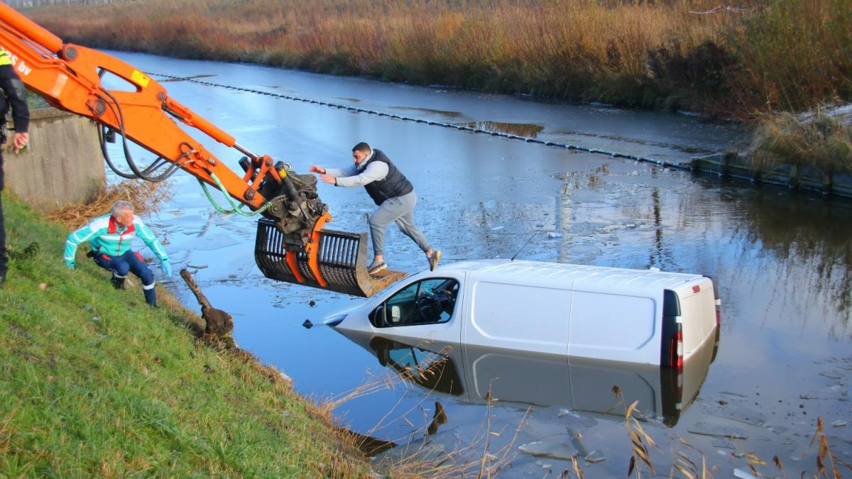 Graafmachine redt automobilist uit ijzige sloot in Spaarndam