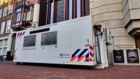 Mobiele forensische eenheid van de politie amsterdam-amstelland geparkeerd in een stadsstraat.