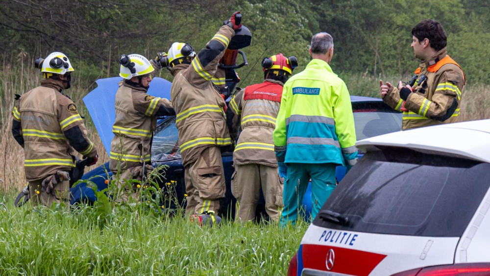 Brandweer bevrijdt slachtoffer uit auto na botsing met boom in Nijkerk.