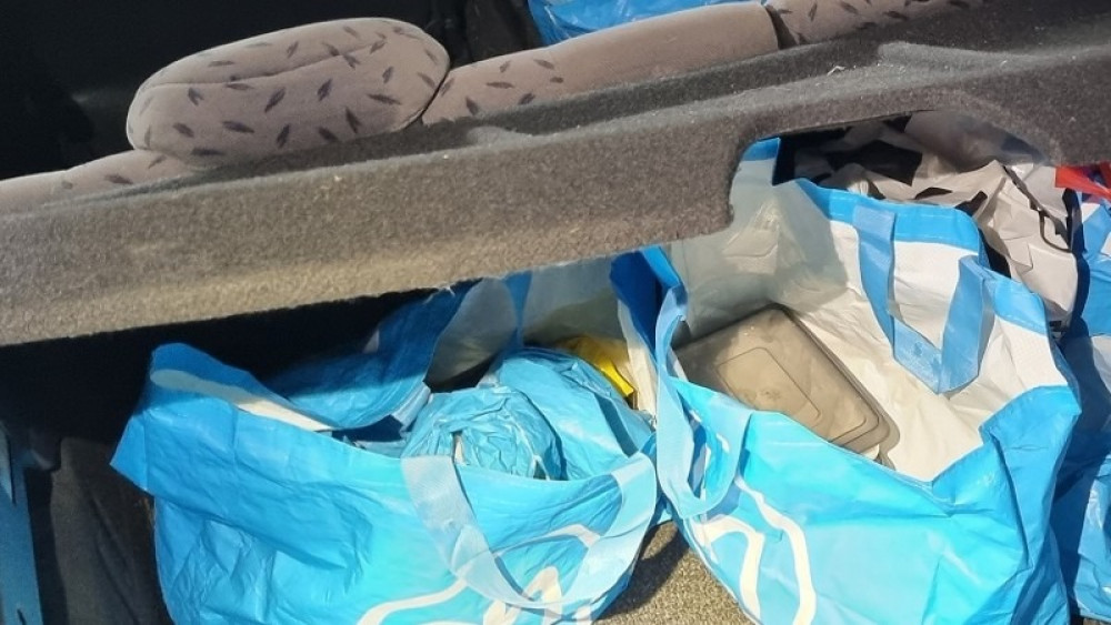 Kofferbak van een van de voertuigen met vermoedelijk tassen harddrugs