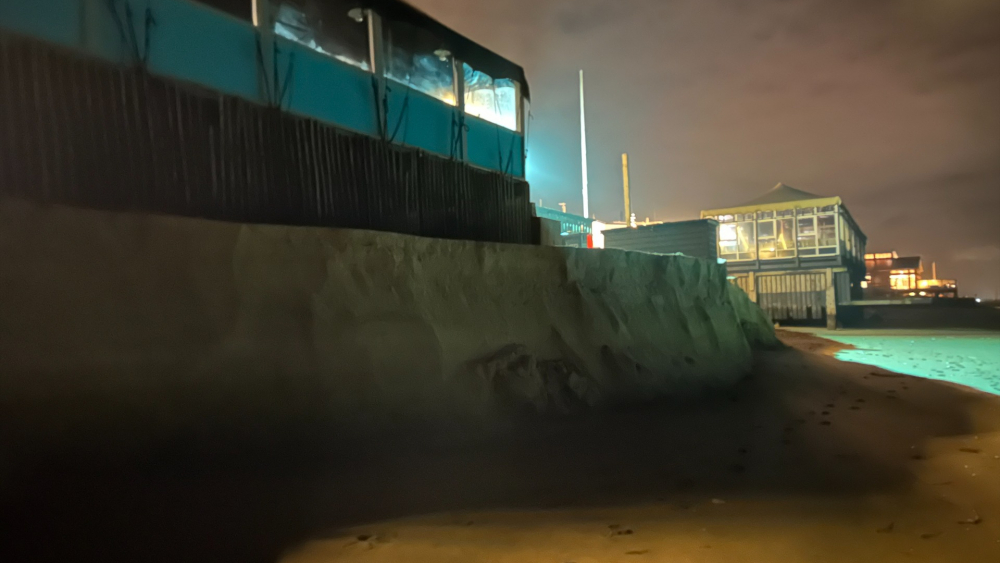 Een gebouw op het strand bij nacht.