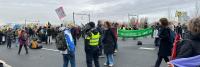 Een groep mensen die borden op straat vasthouden.