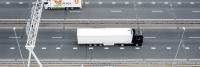 Luchtfoto van een witte semi-vrachtwagen die op een snelweg rijdt met meerdere lege rijstroken, vergezeld van een dienstvoertuig met het opschrift "van perren" dat langszij rijdt.