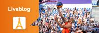 Een basketbalspeler in oranje uniform springt tijdens een wedstrijd om de bal in de ring te schieten, met een menigte toeschouwers op de achtergrond. Aan de linkerkant staat een oranje banner met de tekst "Liveblog" en een icoon van de Eiffeltoren.