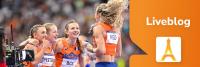 Vier vrouwelijke atleten, gekleed in oranje uniformen die Nederland vertegenwoordigen, vieren samen feest op een racebaan. Een camera legt het moment vast. De afbeelding bevat een "Liveblog"-icoon met een Eiffeltoren-afbeelding op een oranje achtergrond.