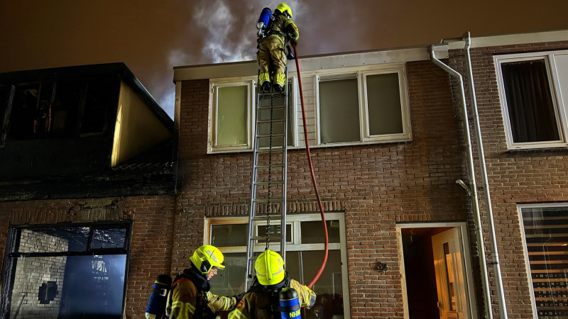 Brandweerlieden bij woningbrand Den Helder