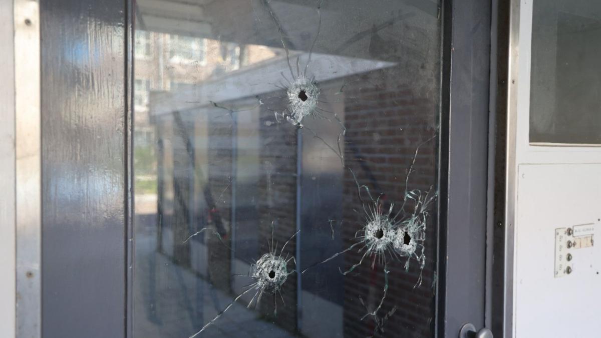 Kogelgaten in portiek van flat in Geuzenveld