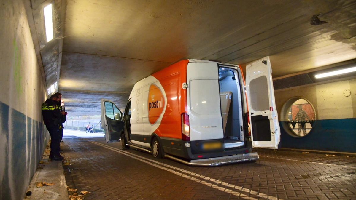 Postbezorger rijdt zich met zijn busje klem onder spoorviaduct