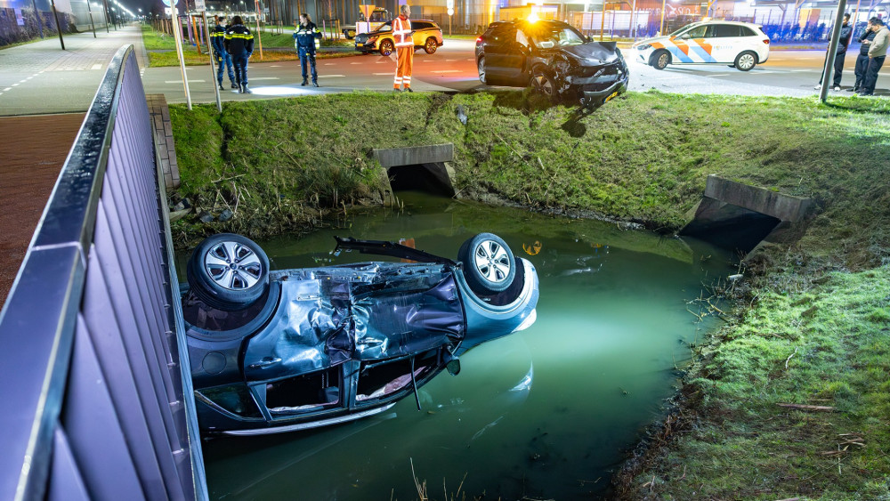 Taxi ends up on its side in water after collision