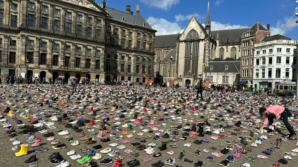 Dam in Amsterdam bezaaid met kinderschoenen ter nagedachtenis vermoorde kinderen in Gaza