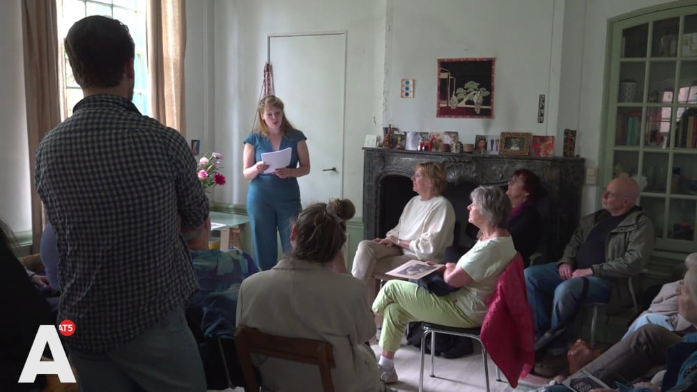 People listen to the story of resistance fighter Aunt Cor from her former home