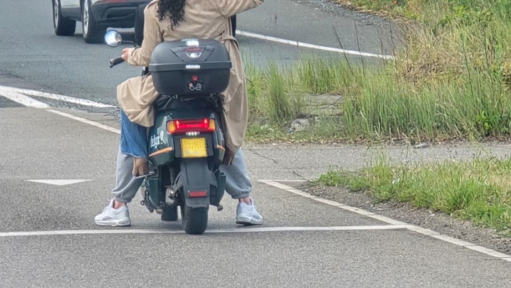 Duo on rental scooter takes selfie at A10 Sloten on-ramp