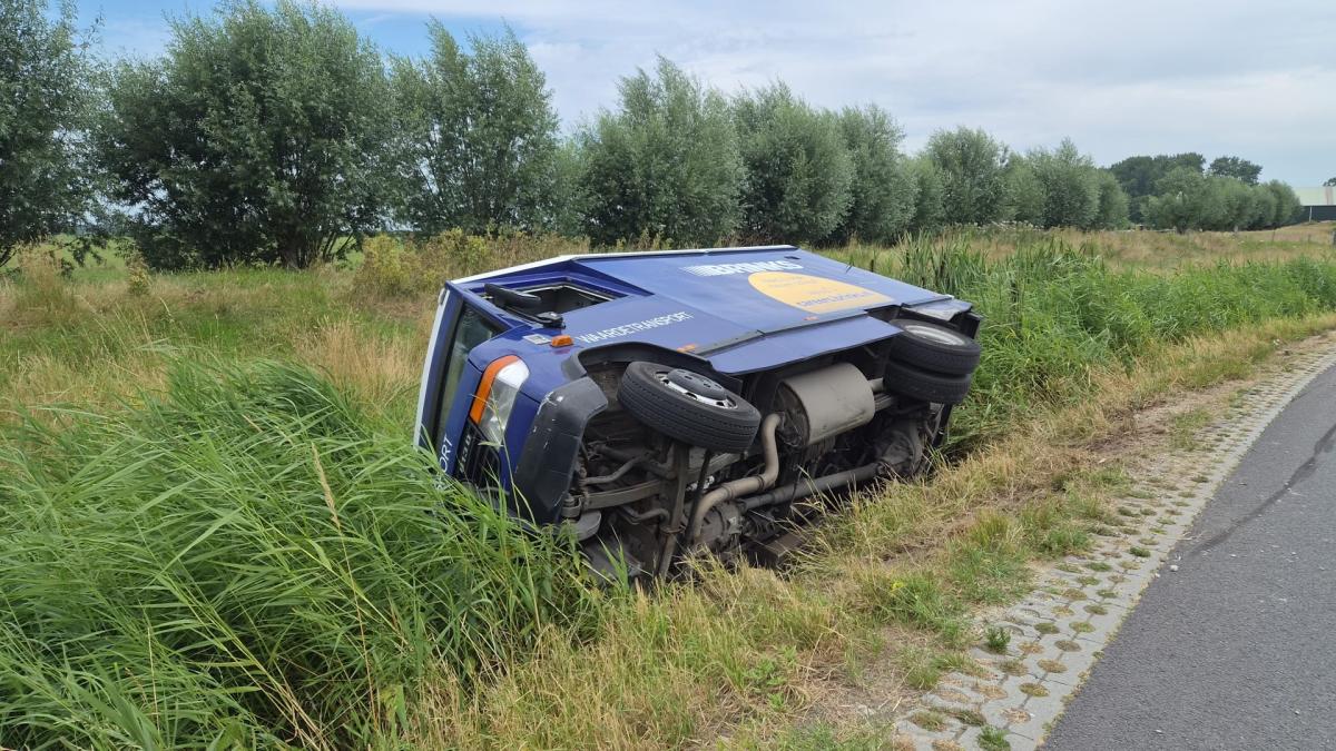 Flinke politiemacht bewaakt van de weg geraakte geldtransportwagen