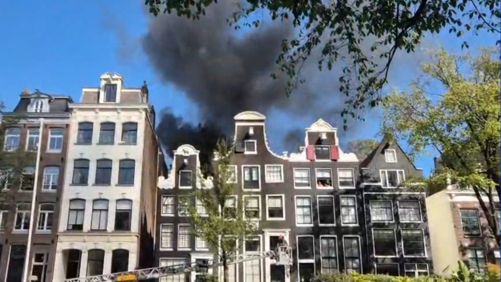 Major fire in house on Prinsengracht, black smoke visible over city center