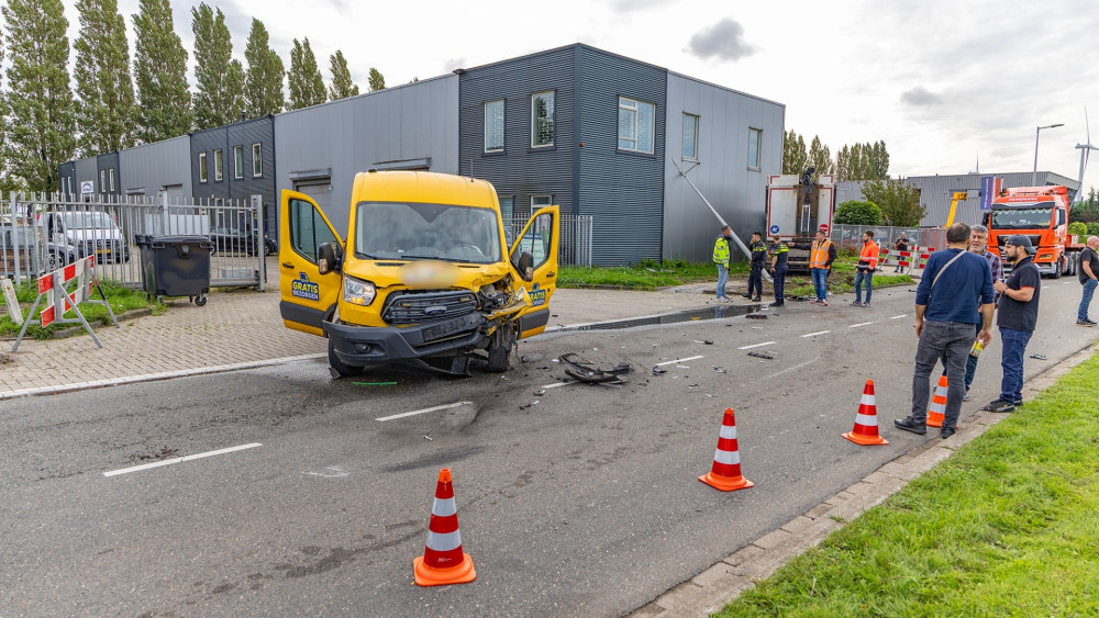 Truck comes to a halt just before office building after collision with van